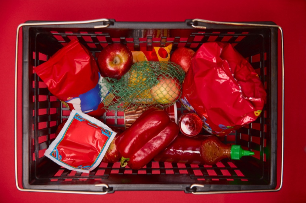A shopping basket of red groceries seen from above